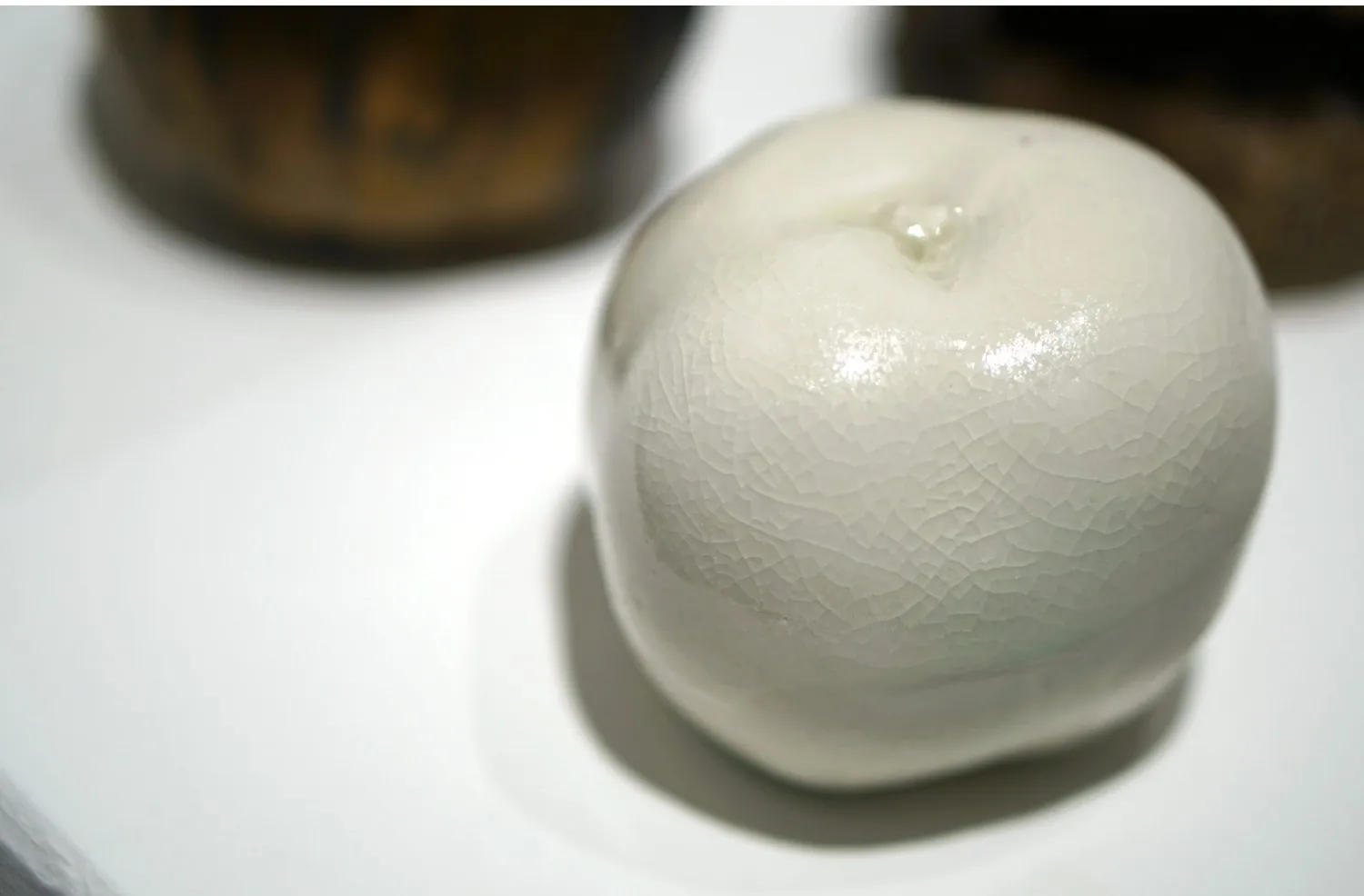 Pale porcelain apple with a subtle textured surface.