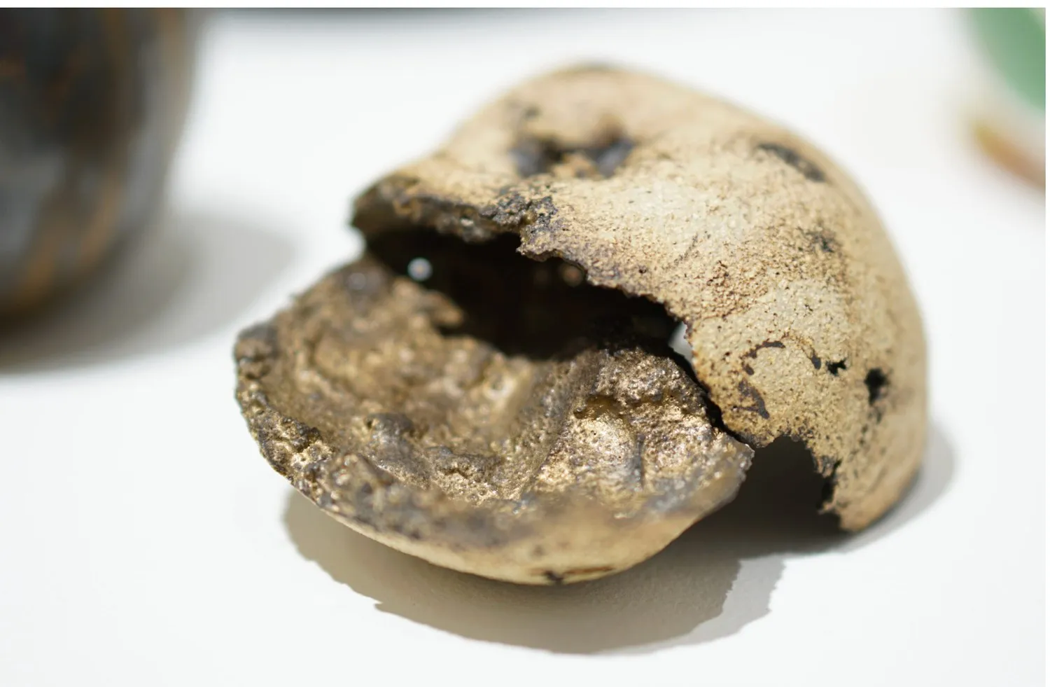 A broken, dark and pale porcelain apple.