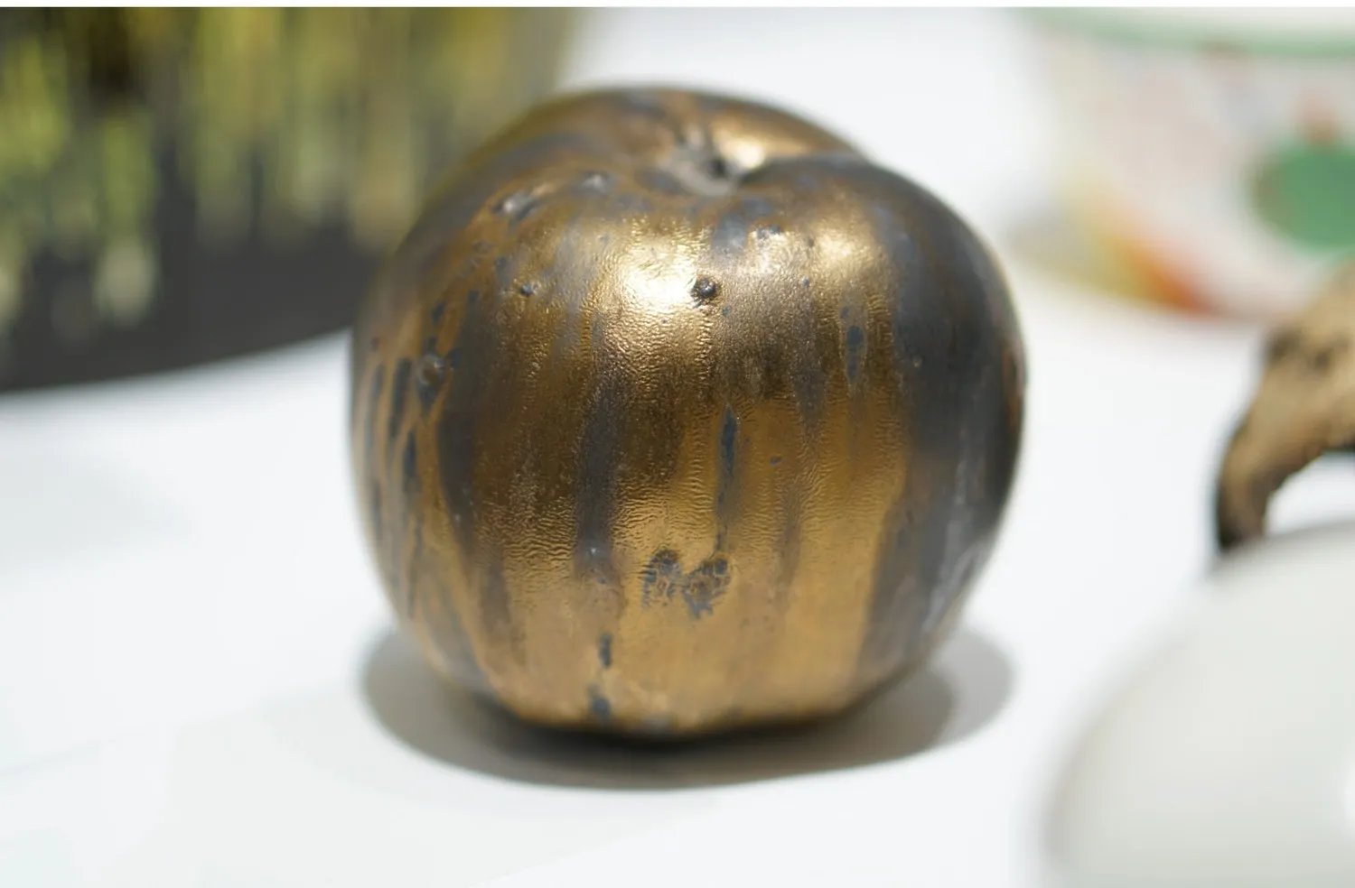 A metallic golden porcelain apple.