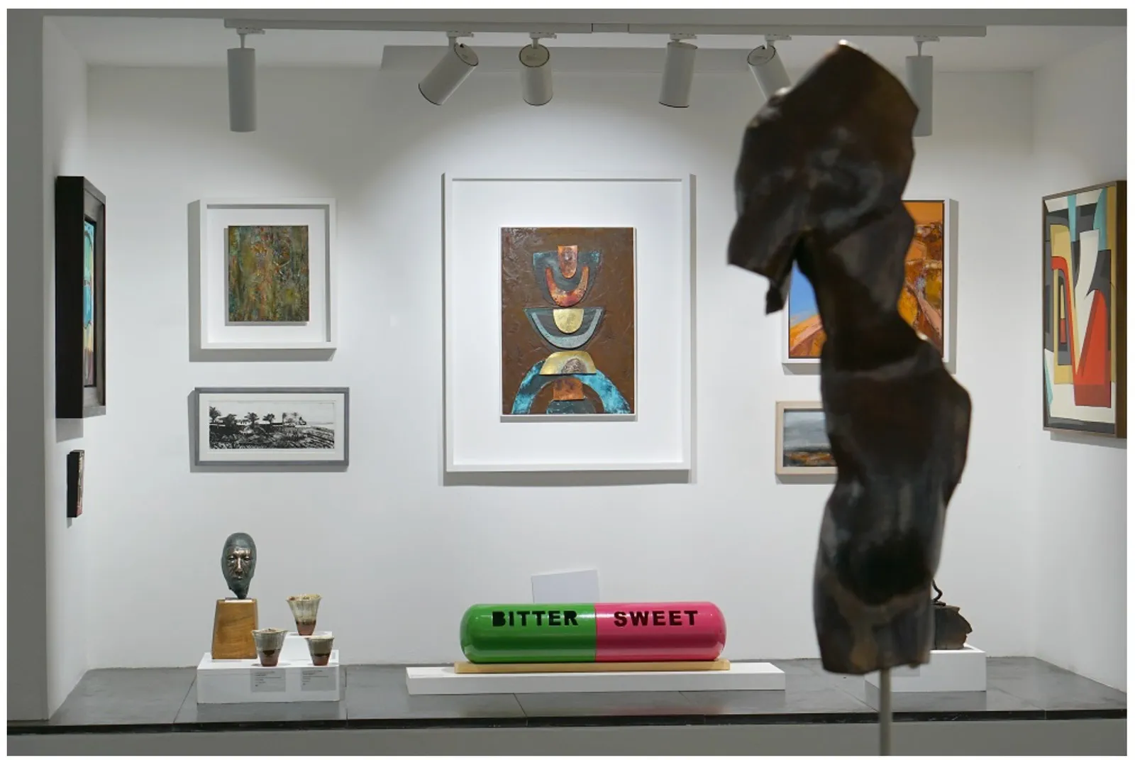 Wider gallery view with Juliette’s small fungi vessels among sculpture and paintings.