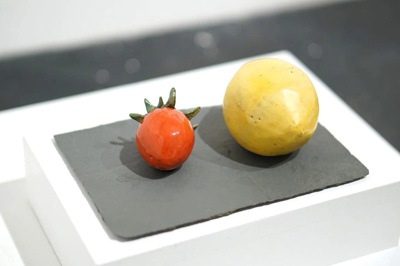 An alternative view of the ceramic strawberry and lemon showing their textured glazed surfaces.